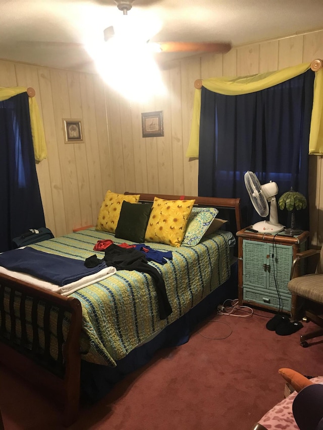 carpeted bedroom featuring wooden walls