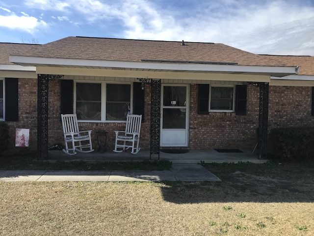 back of house with a porch and a yard