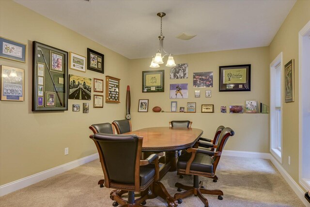 dining space with light colored carpet and a chandelier