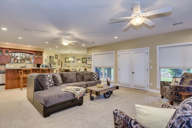 living room with ceiling fan and light colored carpet