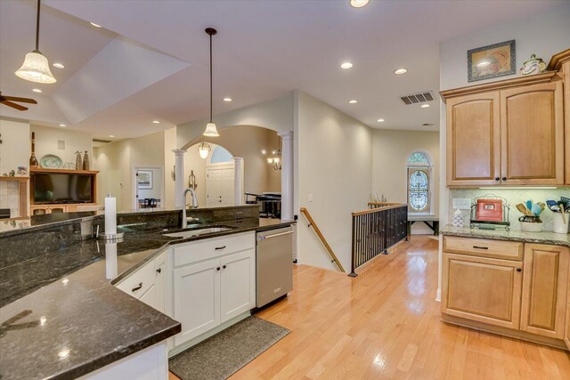 kitchen with pendant lighting, dishwasher, backsplash, dark stone counters, and sink