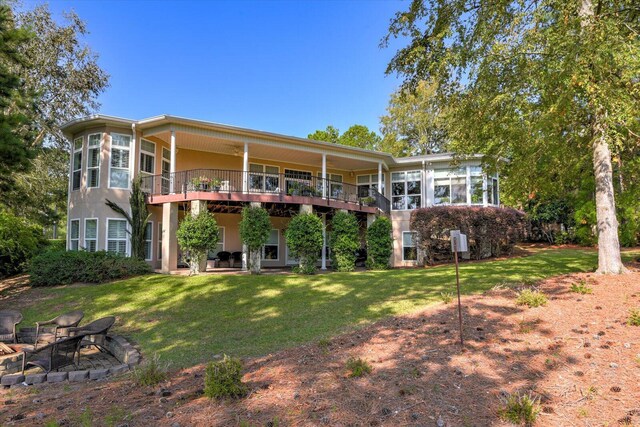 back of property featuring a sunroom and a yard