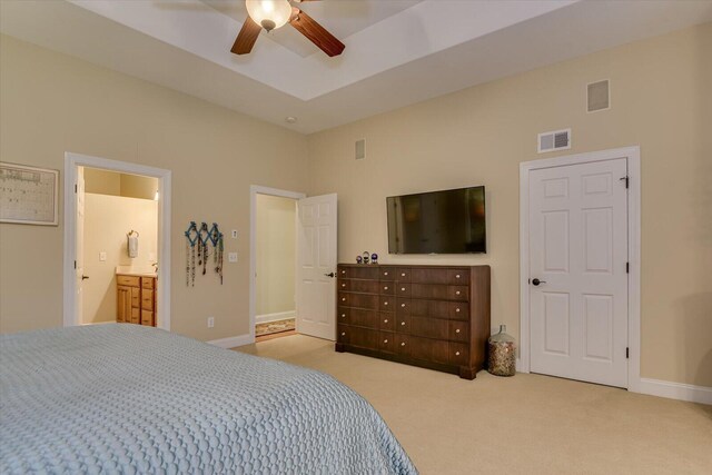 carpeted bedroom featuring ceiling fan and ensuite bath