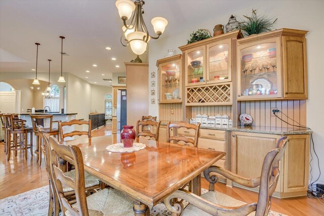 dining room with light hardwood / wood-style floors and a notable chandelier