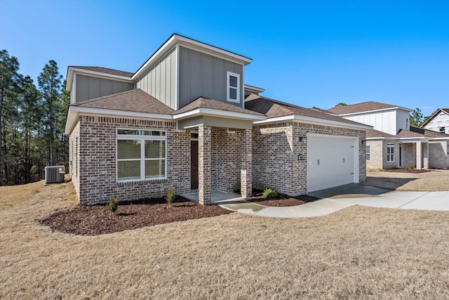 view of front of property with a garage, central AC unit, and a front lawn