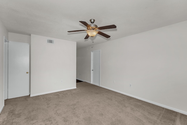 empty room featuring ceiling fan and light colored carpet