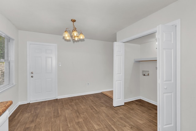 unfurnished dining area with hardwood / wood-style floors and a chandelier