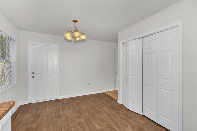 unfurnished dining area with a chandelier and hardwood / wood-style floors