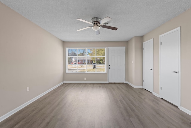 spare room featuring a ceiling fan, baseboards, and wood finished floors