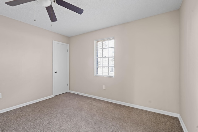 carpeted empty room featuring a textured ceiling, a ceiling fan, and baseboards