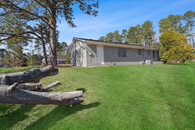 rear view of property with brick siding and a yard