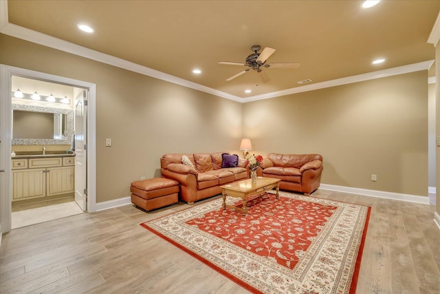 living room with sink, crown molding, light hardwood / wood-style flooring, and ceiling fan