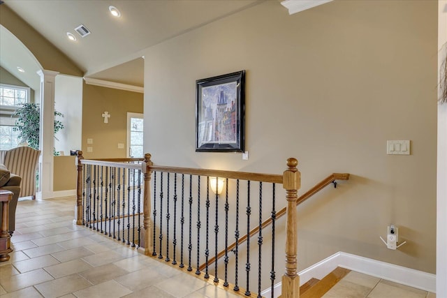 corridor featuring decorative columns, light tile patterned flooring, lofted ceiling, and crown molding