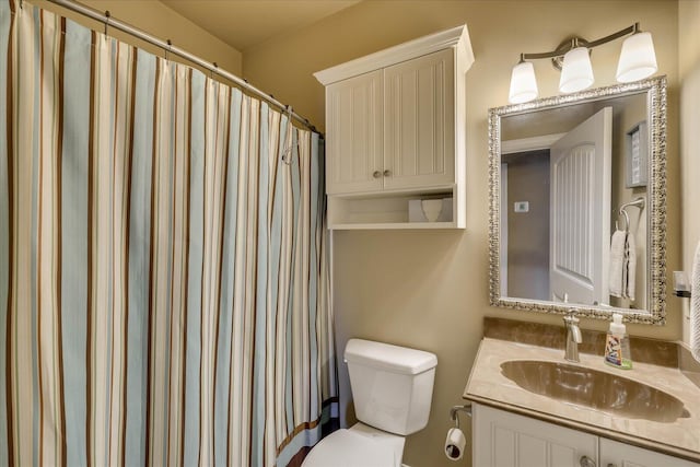 bathroom featuring vanity, toilet, and curtained shower