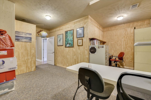 carpeted office space with wooden walls and a textured ceiling