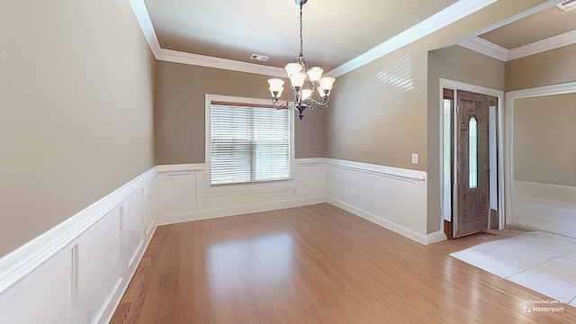 unfurnished room featuring crown molding, a notable chandelier, and light hardwood / wood-style flooring