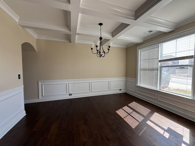 spare room featuring an inviting chandelier, beam ceiling, coffered ceiling, and dark wood-style flooring