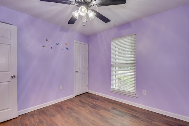 unfurnished room with ceiling fan and dark wood-type flooring