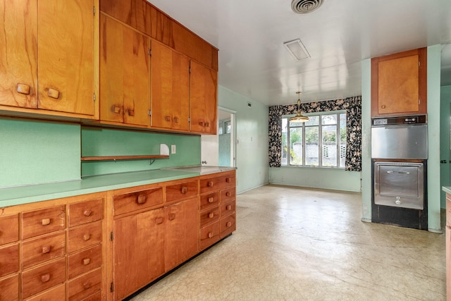 kitchen with stainless steel oven and hanging light fixtures