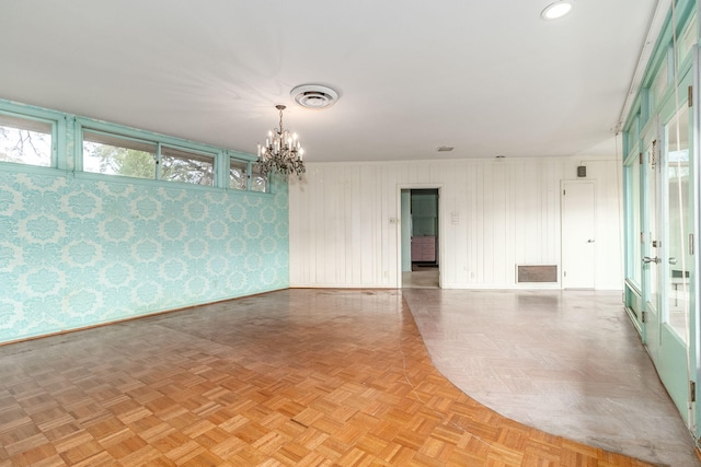 spare room with a chandelier and light parquet floors