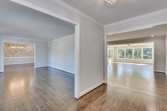 unfurnished room featuring ornamental molding, a notable chandelier, and wood finished floors