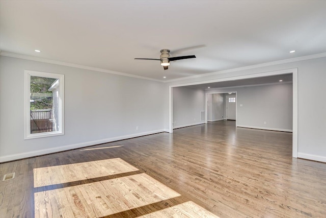 spare room with crown molding, recessed lighting, a ceiling fan, wood finished floors, and baseboards