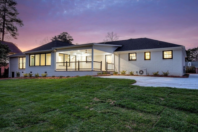 view of front facade with a porch, crawl space, brick siding, and a lawn