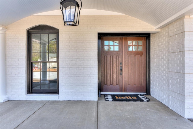 entrance to property featuring brick siding