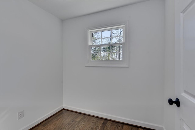 empty room featuring dark wood-style floors and baseboards