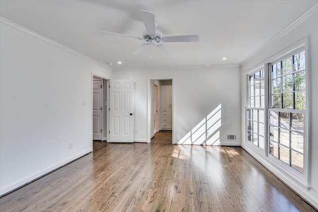 unfurnished room with recessed lighting, wood finished floors, visible vents, baseboards, and crown molding