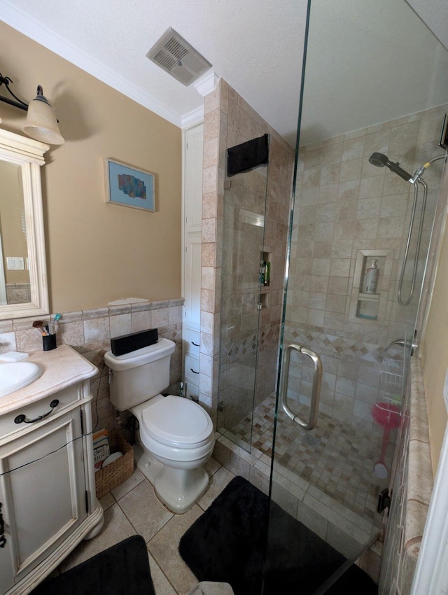 bathroom featuring visible vents, toilet, tile walls, a shower stall, and tile patterned flooring