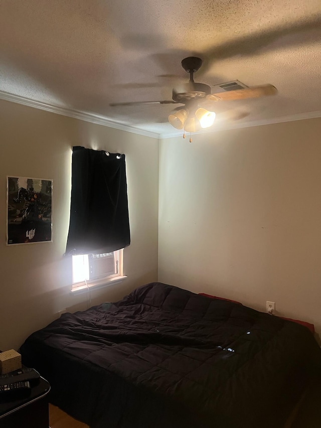 bedroom featuring visible vents, a textured ceiling, ceiling fan, and crown molding