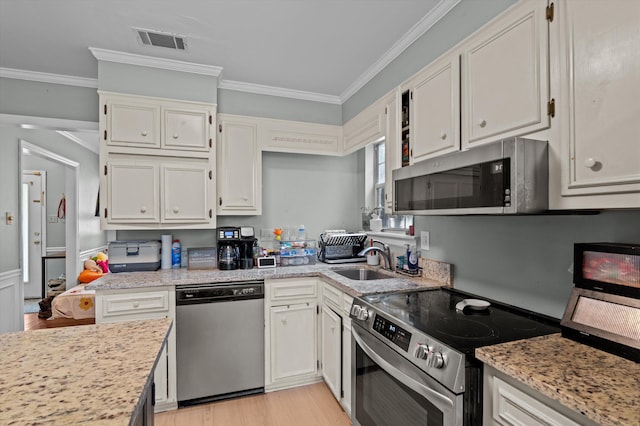 106 Moss Creek Dr, Martinez, GA 30907 - kitchen featuring appliances with stainless steel finishes, ornamental molding, a sink, light wood-style flooring, and white cabinetry
