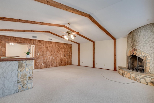 unfurnished living room featuring vaulted ceiling with beams, a fireplace, visible vents, and carpet floors