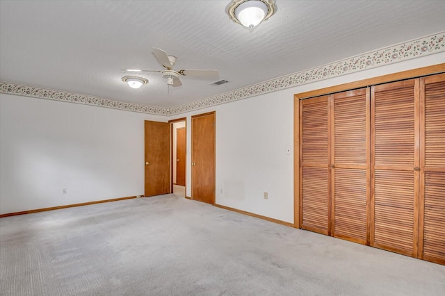 unfurnished bedroom featuring carpet, visible vents, baseboards, a closet, and a textured ceiling