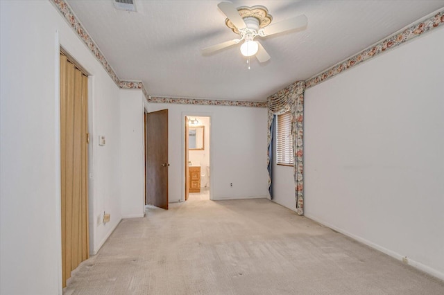 unfurnished bedroom with a ceiling fan, visible vents, ensuite bathroom, a textured ceiling, and light colored carpet