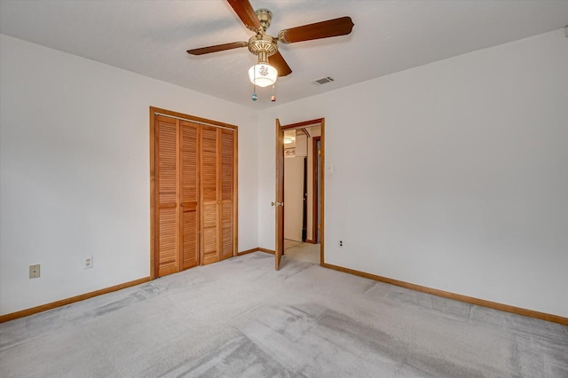 unfurnished bedroom with baseboards, visible vents, carpet floors, ceiling fan, and a closet