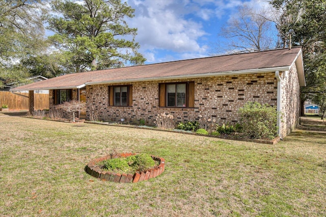 ranch-style house featuring a front lawn, fence, and brick siding