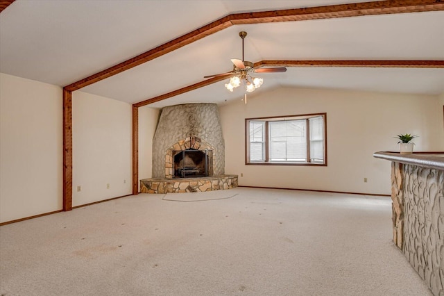 unfurnished living room with a stone fireplace, carpet, lofted ceiling with beams, and baseboards