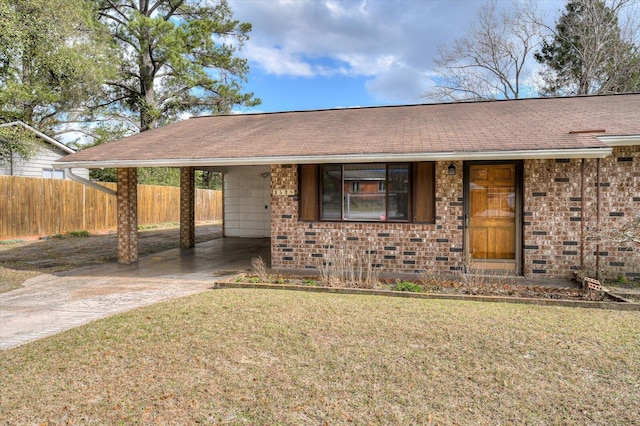 ranch-style house with brick siding, an attached carport, fence, concrete driveway, and a front yard