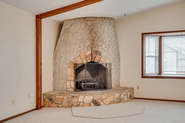 room details with a stone fireplace, beamed ceiling, carpet flooring, and baseboards