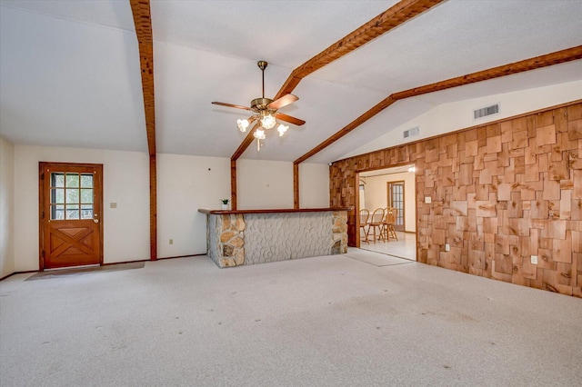 interior space with visible vents, lofted ceiling with beams, a ceiling fan, and carpet floors