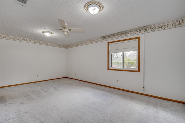 unfurnished room with visible vents, light colored carpet, ceiling fan, and a textured ceiling