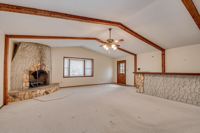 unfurnished living room with a stone fireplace, lofted ceiling with beams, a ceiling fan, and light carpet