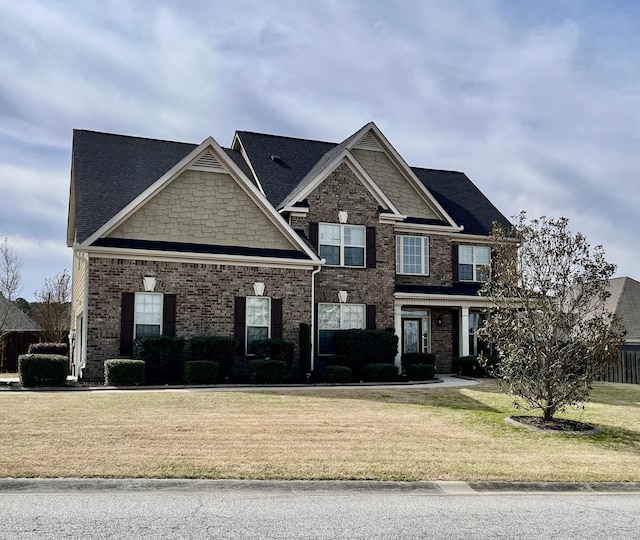 craftsman-style home featuring brick siding and a front yard