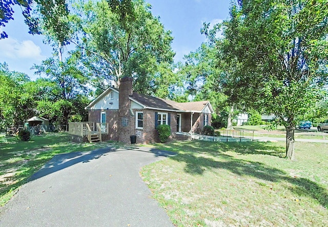 1904 Robin Rd, North Augusta, SC 29841 - view of front of home featuring brick siding, a chimney, a front lawn, asphalt driveway, and a deck