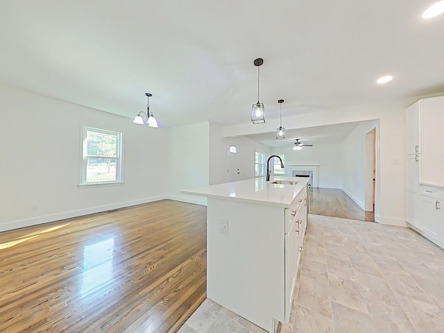 1904 Robin Rd, North Augusta, SC 29841 - kitchen featuring open floor plan, light countertops, a chandelier, white cabinetry, and a center island with sink