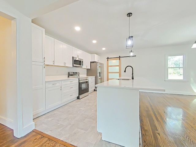 1904 Robin Rd, North Augusta, SC 29841 - kitchen featuring stainless steel appliances, a barn door, light countertops, white cabinetry, and recessed lighting