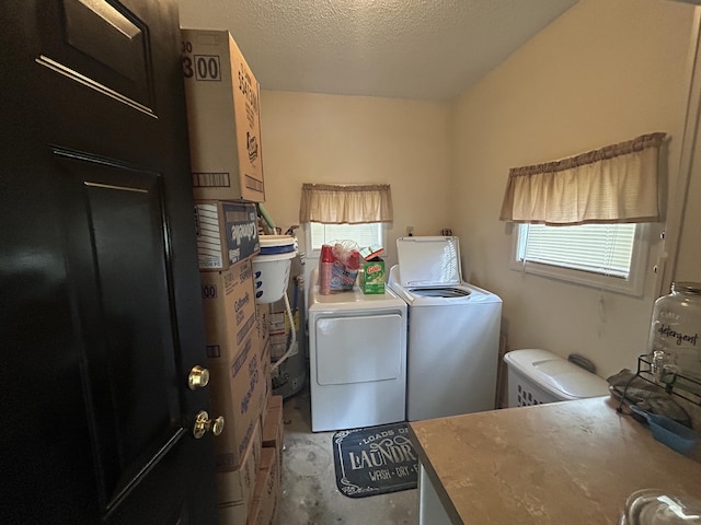 clothes washing area featuring a textured ceiling, laundry area, and independent washer and dryer