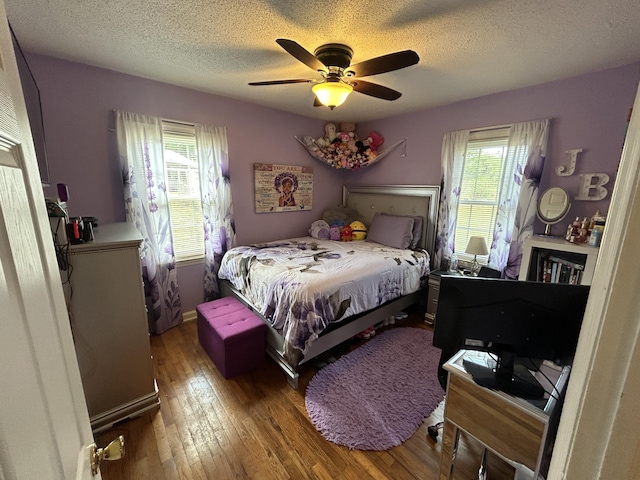 bedroom featuring a textured ceiling, hardwood / wood-style floors, and a ceiling fan